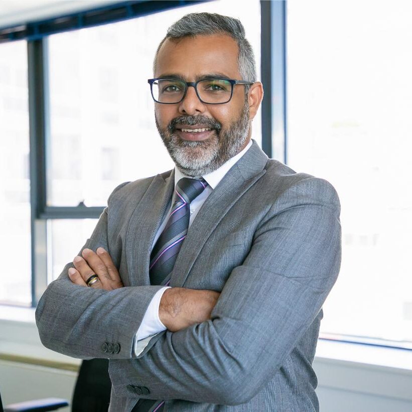 experienced-businessman-standing-office-room-indian-content-office-employee-eyeglasses-smiling-posing-with-folded-hands-business-management-corporation-concept